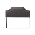 Tête de lit en tissu capitonné avec motifs géométriques en bois découpé et clous décoratifs
